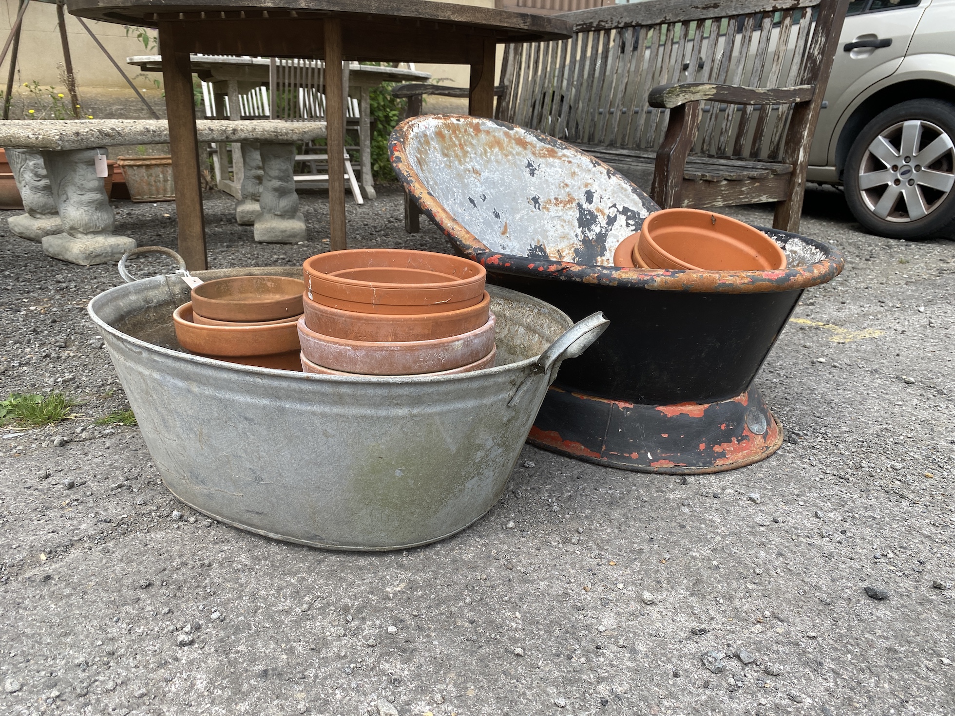 A vintage galvanised hip bath, height 54cm, an oval galvanised two handled grain trough and a quantity of terracotta pots